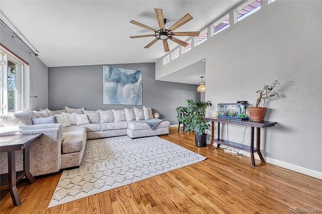 living area with wood finished floors, ceiling fan, baseboards, and a textured wall