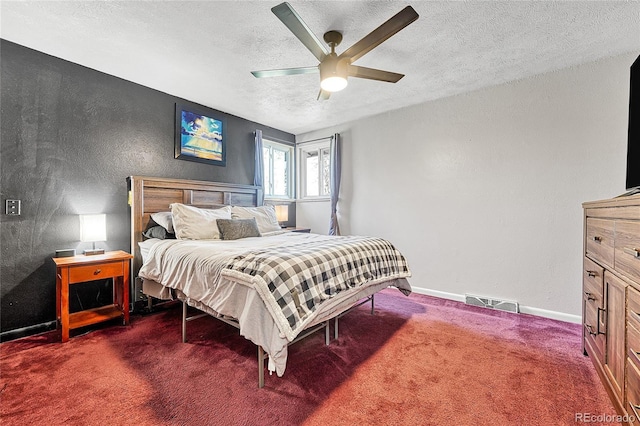 bedroom with a textured ceiling, dark colored carpet, a textured wall, and ceiling fan