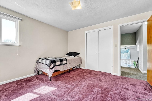 carpeted bedroom with a closet, baseboards, and a textured ceiling