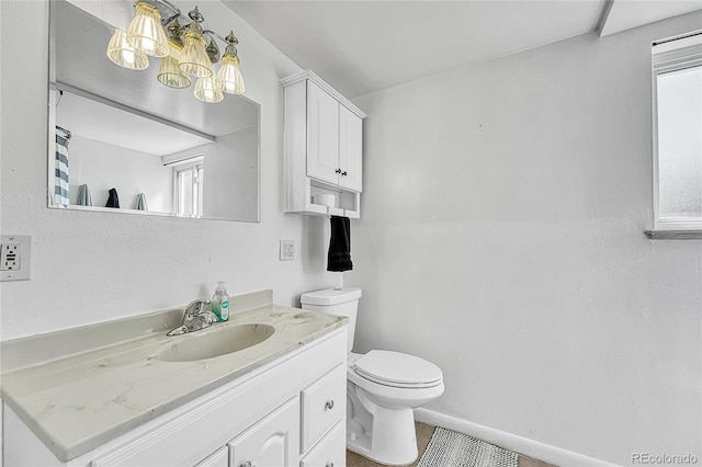 bathroom featuring toilet, vanity, and a chandelier