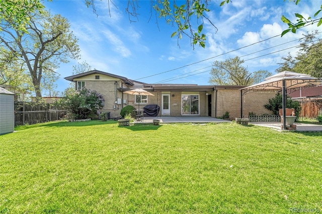 back of house featuring brick siding, a patio, and a gazebo