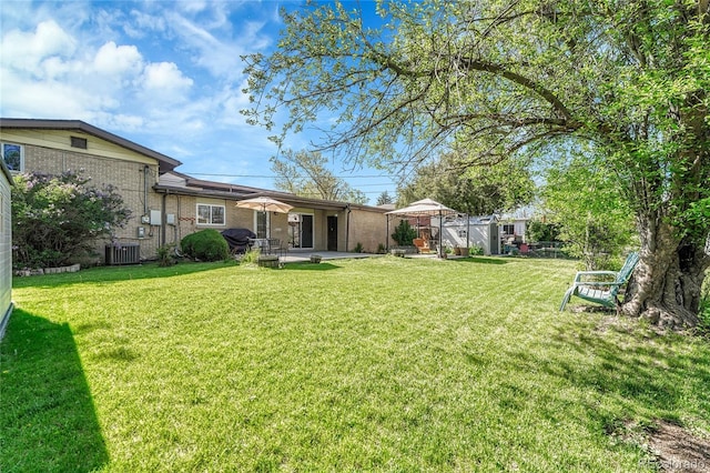 view of yard with central AC and a patio