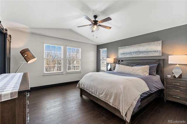 bedroom with lofted ceiling, dark hardwood / wood-style floors, ceiling fan, and a barn door