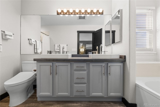 full bathroom with wood-type flooring, toilet, shower with separate bathtub, and vanity