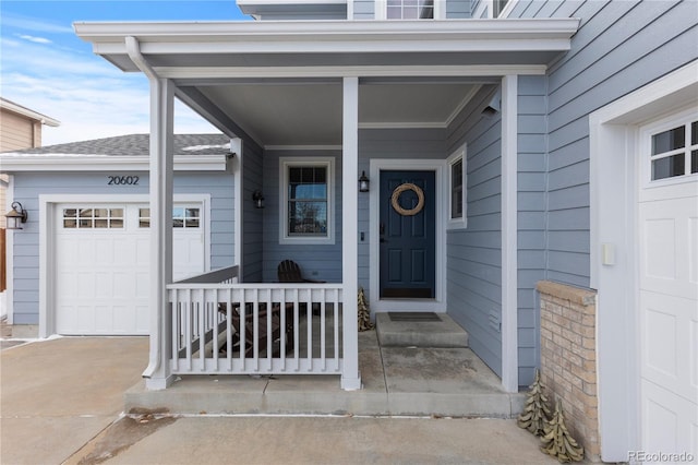 view of exterior entry featuring a garage and covered porch