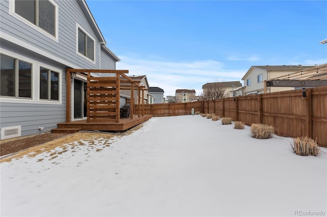 yard covered in snow with a wooden deck