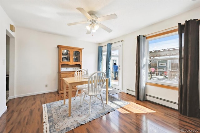 dining space featuring a baseboard heating unit, wood finished floors, and ceiling fan