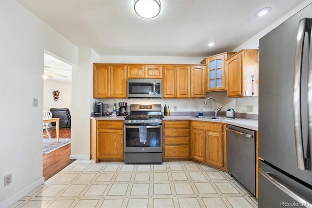 kitchen featuring glass insert cabinets, light floors, stainless steel appliances, and light countertops