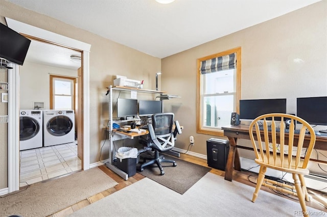 office area with washer and dryer, baseboards, and wood finished floors