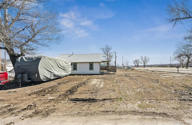 rear view of house featuring metal roof