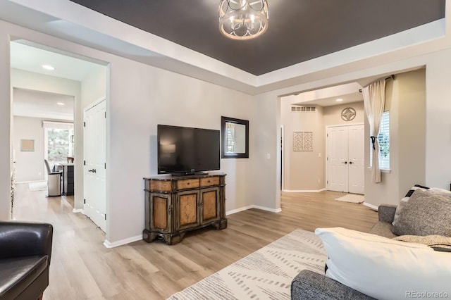 living room featuring light wood-style flooring, a chandelier, baseboards, and recessed lighting