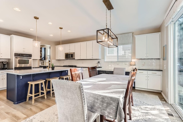 dining area with light wood-style floors, a chandelier, and recessed lighting