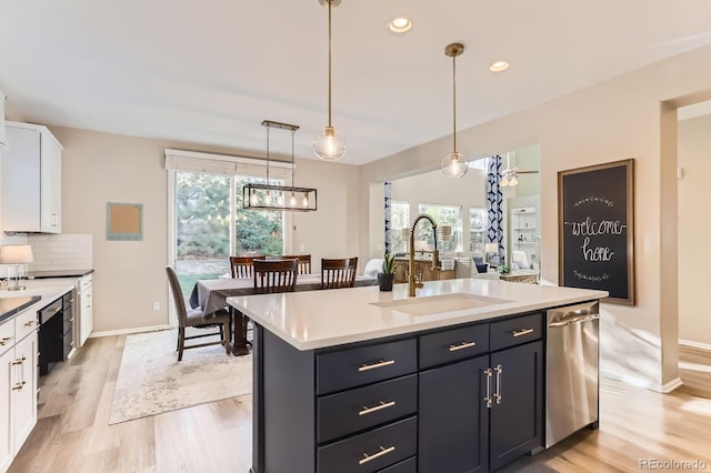 kitchen with a sink, white cabinets, plenty of natural light, light wood-style floors, and recessed lighting