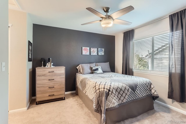 bedroom with light colored carpet, baseboards, and ceiling fan