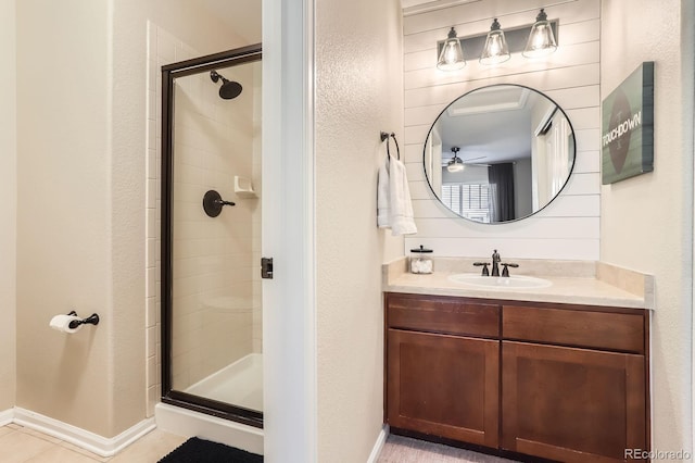 bathroom with a stall shower, vanity, a textured wall, and ceiling fan