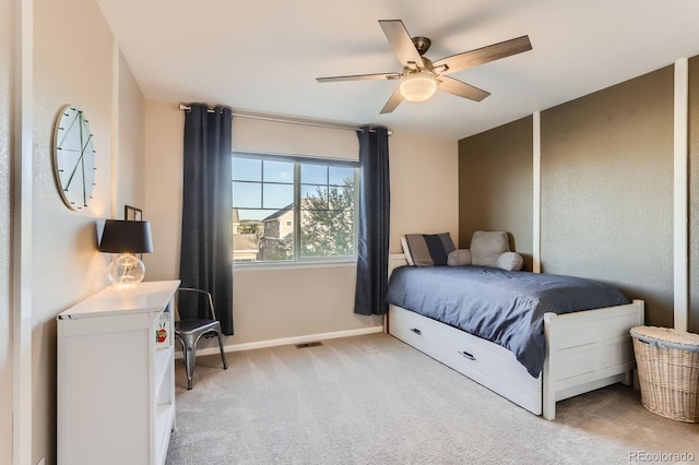 bedroom featuring light colored carpet, baseboards, and a ceiling fan
