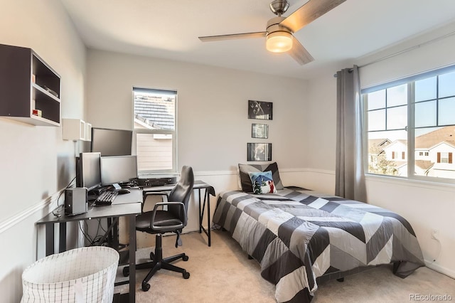 bedroom featuring light carpet, a desk, and ceiling fan