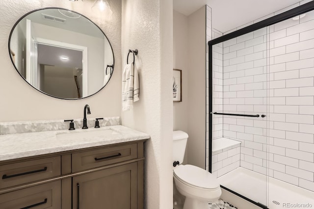 full bathroom with toilet, a tile shower, and vanity