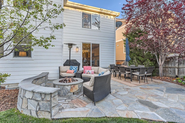rear view of property with an outdoor fire pit, a patio area, fence, and outdoor dining space
