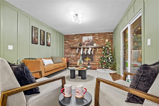 living room featuring brick wall, a brick fireplace, and a healthy amount of sunlight