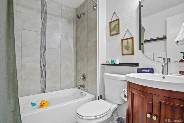 full bathroom with tiled shower / bath combo, vanity, and toilet