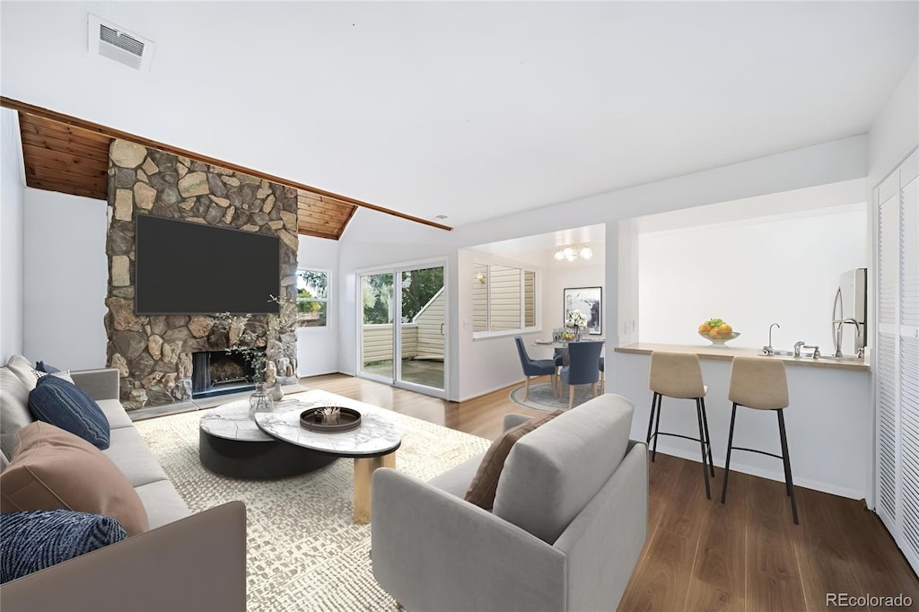 living room with a fireplace, lofted ceiling, and dark hardwood / wood-style floors