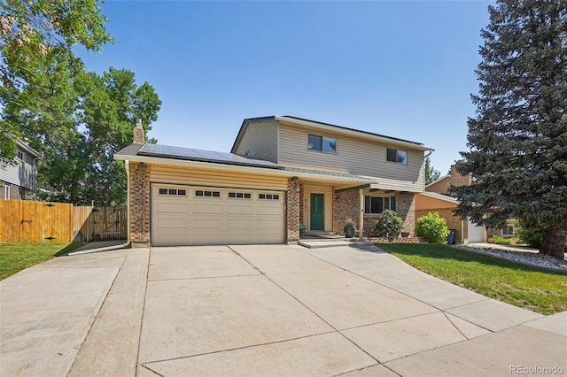 6121 W 108th Ave, Westminster, CO 80020 - traditional home with brick siding, a chimney, solar panels, concrete driveway, and an attached garage