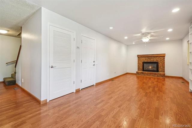 6121 W 108th Ave, Westminster, CO 80020 - unfurnished living room featuring ceiling fan, light wood finished floors, recessed lighting, stairs, and a brick fireplace