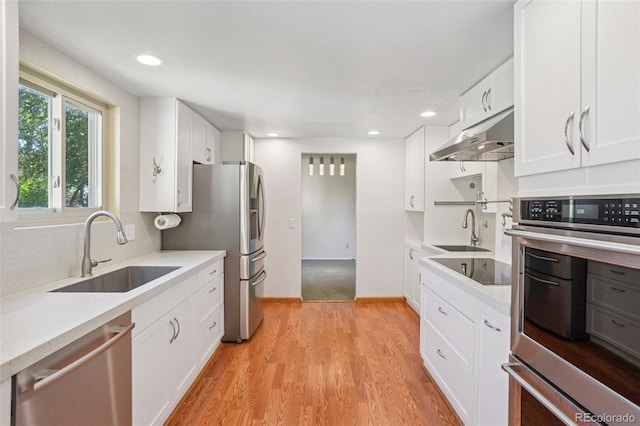 6121 W 108th Ave, Westminster, CO 80020 - kitchen with appliances with stainless steel finishes, under cabinet range hood, white cabinetry, light countertops, and recessed lighting