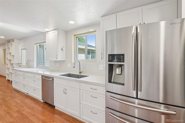 6121 W 108th Ave, Westminster, CO 80020 - kitchen with appliances with stainless steel finishes, light countertops, white cabinetry, light wood-style flooring, and recessed lighting