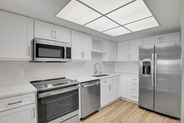 14001 E Marina Dr Unit 603, Aurora, CO 80014 - kitchen featuring white cabinets, appliances with stainless steel finishes, a sink, and tasteful backsplash