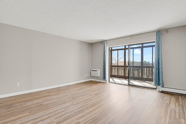 14001 E Marina Dr Unit 603, Aurora, CO 80014 - unfurnished room with baseboards, an AC wall unit, a textured ceiling, and wood finished floors