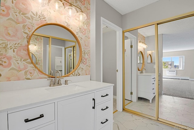 14001 E Marina Dr Unit 603, Aurora, CO 80014 - bathroom featuring vanity, baseboards, wallpapered walls, a textured ceiling, and a wall mounted AC