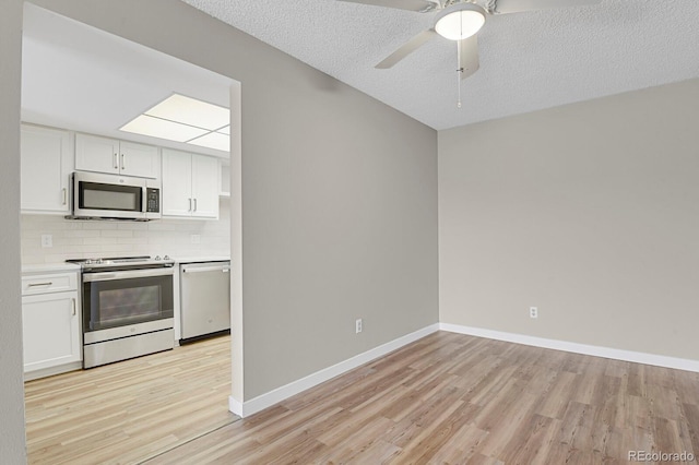 14001 E Marina Dr Unit 603, Aurora, CO 80014 - kitchen featuring appliances with stainless steel finishes, light wood-style floors, white cabinetry, decorative backsplash, and a textured ceiling