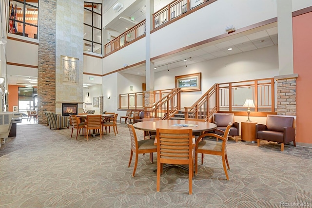14001 E Marina Dr Unit 603, Aurora, CO 80014 - carpeted dining area featuring a towering ceiling, stairway, and a tile fireplace