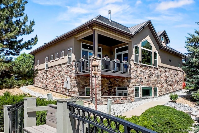 6532 S Tempe St, Aurora, CO 80016 - view of property exterior featuring a balcony, stone siding, and stucco siding