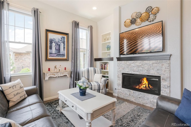25049 E Alder Dr, Aurora, CO 80016 - living room featuring a stone fireplace, baseboards, built in features, and wood finished floors