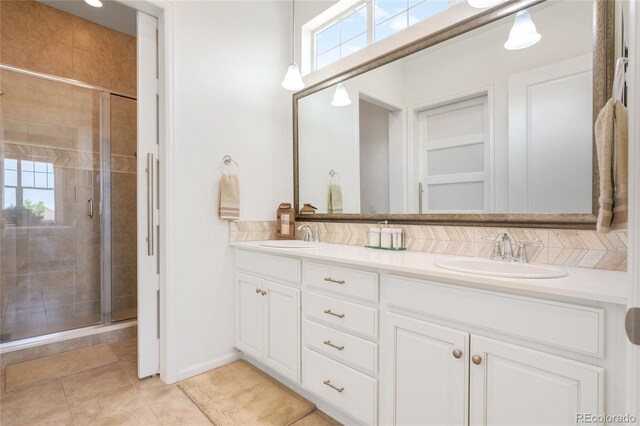 25049 E Alder Dr, Aurora, CO 80016 - full bathroom featuring double vanity, a shower stall, decorative backsplash, and plenty of natural light