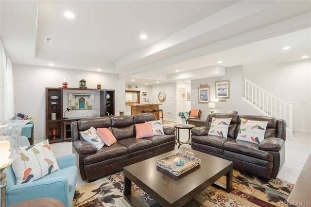 25049 E Alder Dr, Aurora, CO 80016 - living area featuring bar with sink, a tray ceiling, recessed lighting, stairway, and light carpet