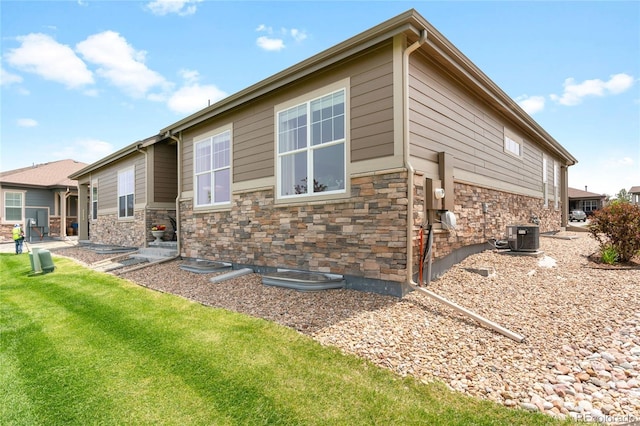 25049 E Alder Dr, Aurora, CO 80016 - rear view of property with stone siding, central AC, and a lawn