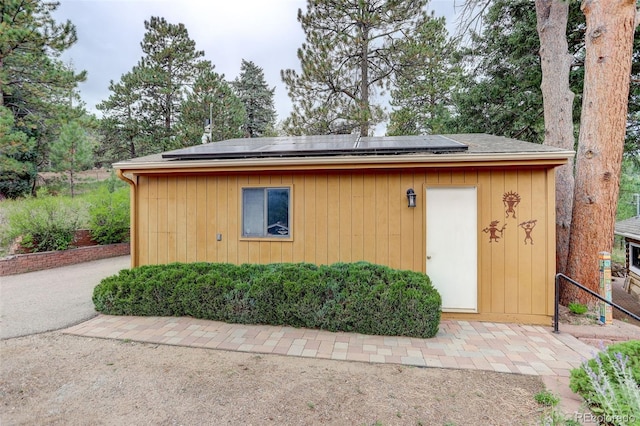 view of outbuilding featuring solar panels