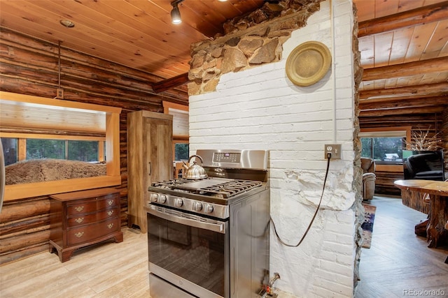 kitchen featuring wood walls, stainless steel gas range oven, wooden ceiling, and light hardwood / wood-style flooring