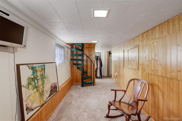 living area with wooden walls and light colored carpet