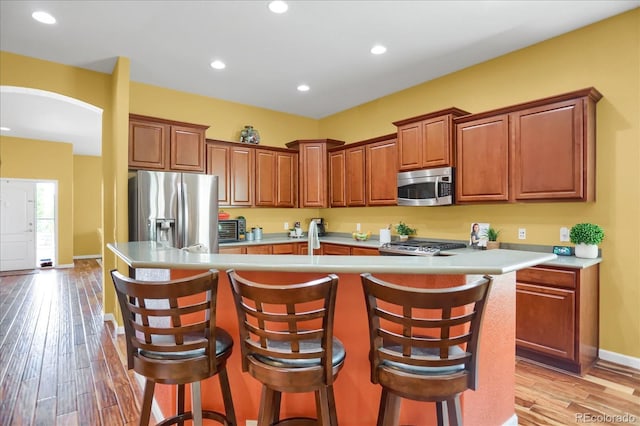 3419 Traver Dr, Broomfield, CO 80023 - kitchen with light countertops, an island with sink, stainless steel appliances, and light wood-style floors