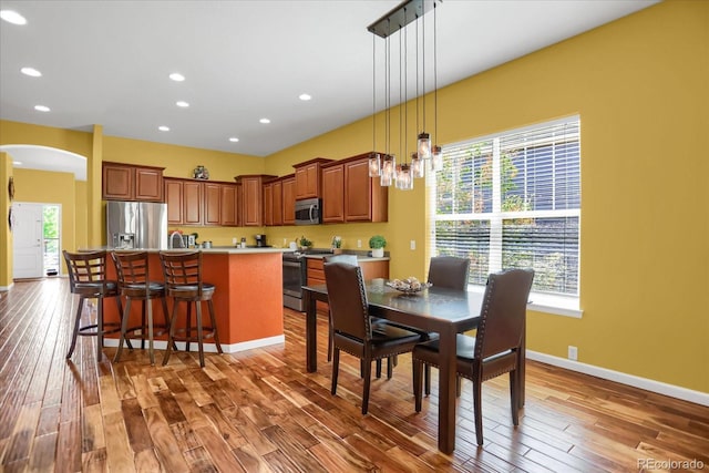3419 Traver Dr, Broomfield, CO 80023 - dining space featuring recessed lighting, arched walkways, baseboards, and wood finished floors