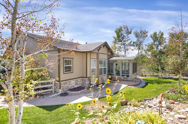 3419 Traver Dr, Broomfield, CO 80023 - rear view of property featuring fence, a sunroom, stone siding, and a yard