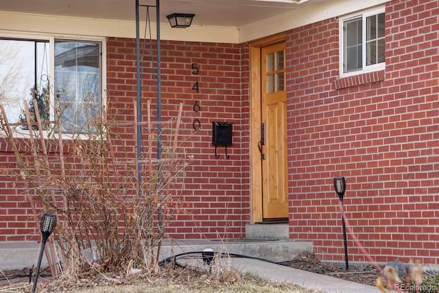 doorway to property featuring brick siding