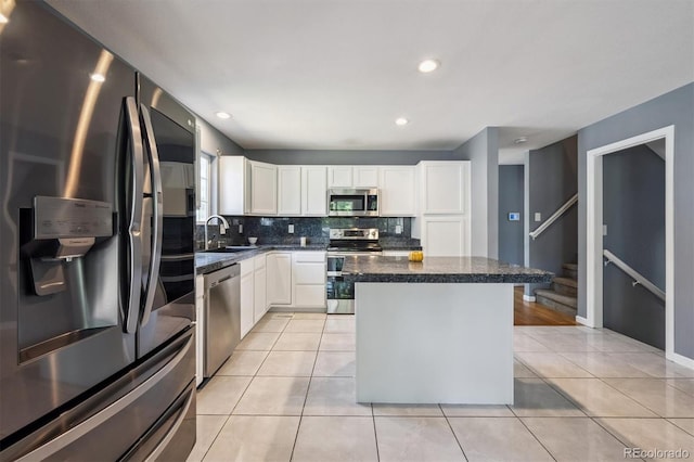 5229 Nighthawk Pkwy, Brighton, CO 80601 - kitchen featuring stainless steel appliances, tasteful backsplash, a center island, white cabinetry, and light tile patterned floors