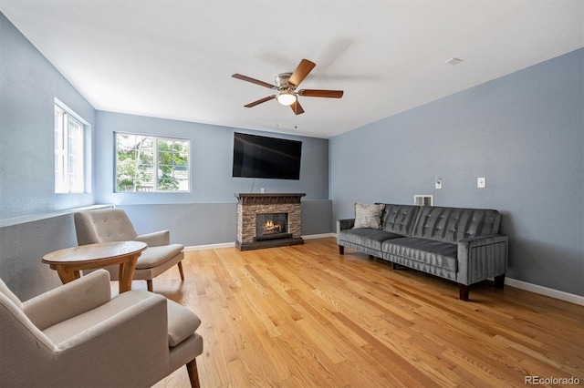 5229 Nighthawk Pkwy, Brighton, CO 80601 - living area featuring light wood-style floors, ceiling fan, and a stone fireplace