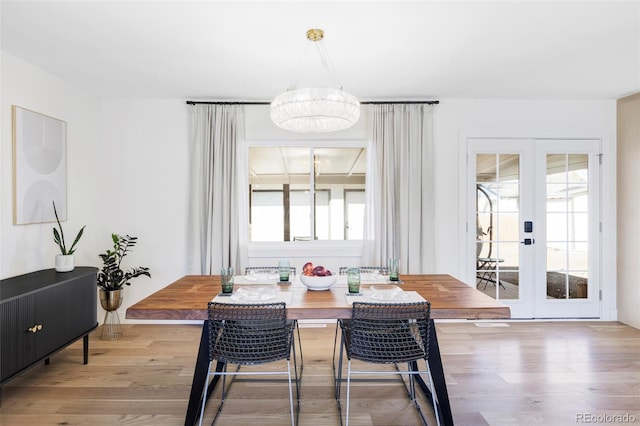 dining room featuring a notable chandelier, wood finished floors, a wealth of natural light, and french doors